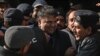 Petugas polisi mengawal mantan menteri informasi Pakistan Fawad Chaudhry (tengah) saat mereka meninggalkan pengadilan setelah sidang di Islamabad pada 27 Januari 2023. (Foto: AFP)