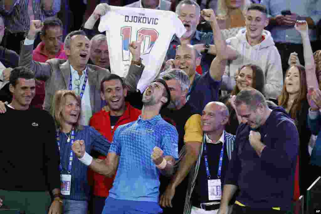 Novak Djokovic of Serbia, center, celebrates with his team including his mother, Dijana, second left, after defeating Stefanos Tsitsipas of Greece in the men&#39;s singles final at the Australian Open tennis championships in Melbourne, Australia.