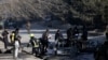 Afghan security officers inspect the site of a bombing attack in Kabul, Afghanistan, Jan. 10, 2021.