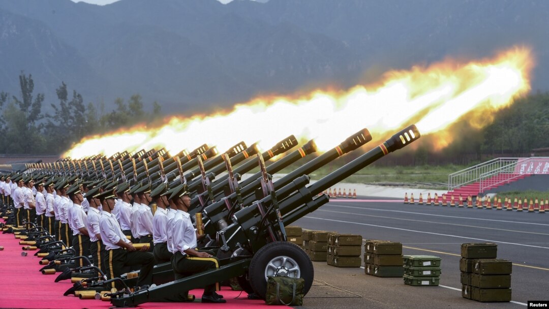 Paramilitary policemen and members of a gun salute team fire cannons during a training session for a military parade to mark the 70th anniversary of the end of the World War Two, at a military base in Beijing, China.