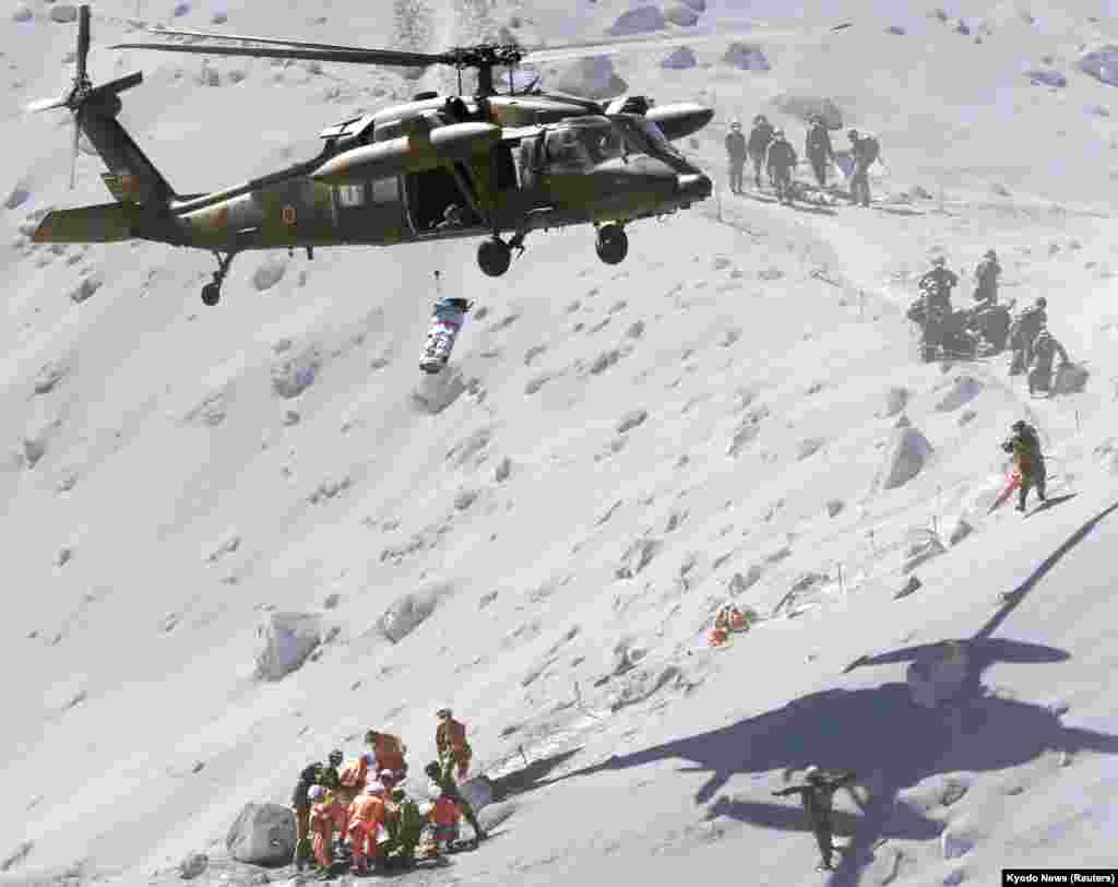Seorang pejalan kaki diangkat dengan helikopter penyelamat dari Pasukan Bela Diri Jepang (JSDF ), dalam operasi penyelamatan di gunung Ontake, yang terbentang di antara wilayah Nagano dan Gifu, Jepang tengah (28/9).