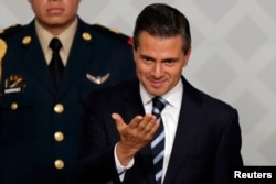 FILE - Mexico's President Enrique Pena Nieto gestures during an event with lawyers in Mexico City, Nov. 21, 2014.