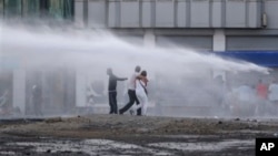 Seorang demonstran menantang meriam air yang ditembakkan polisi anti huru-hara saat berlangsungnya demo anti-pemerintah di Istanbul, Turki, 22 Juni 2013 (Foto: dok). Seorang mahasiswa korban kekerasan saat demo ini, dilaporkan meninggal dunia di rumah sakit, Rabu (10/7), menambah jumlah korban menjadi lima orang.