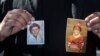 Michael Duran, un plaignant, tient des photos de lui-même lorsqu'il était enfant pendant une conférence de presse pour annoncer les détails d'un règlement de près de 10 millions de dollars de poursuites contre l'archidiocèse de Los Angeles jeudi 14 mars 2013.