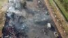 Des personnes se rassemblent autour d'un camion-citerne calciné qui a explosé après avoir été heurté par un camion dans la banlieue de Wellington, dans la capitale de la Sierra Leone, Freetown, samedi 6 novembre 2021. 