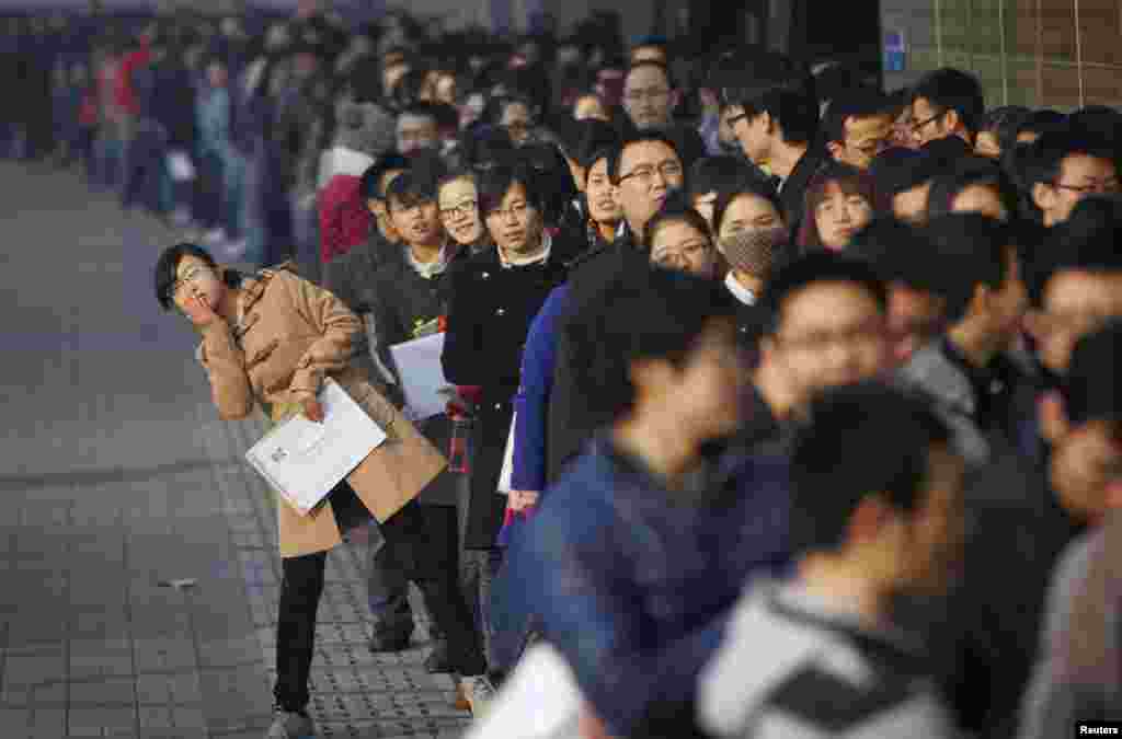Para pencari kerja antri dalam sebuah acara bursa pencari tenaga kerja di Universitas Tianjin di China. Menurut media lokal, lebih dari 6000 orang bergegas ke acara itu pada hari Jumat dengan dibukanya 300 perusahaan.
