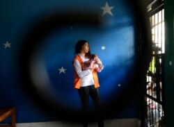 Heather Mack menggendong bayinya di dalam sebuah sel saat menunggu persidangan kasus pembunuhan ibunya berlangsung di Denpasar, Bali, 15 April 2015. (Foto: AFP Sonny Tumbelaka)