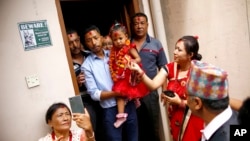 Nepal’s new living goddess Trishna Shakya, 3, is carried by her father as they leave home for a temple palace in Kathmandu, Nepal, Sept. 28, 2017.