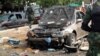 Military officers walk past scene of explosion in Kaduna, northern Nigeria, July 23, 2014.