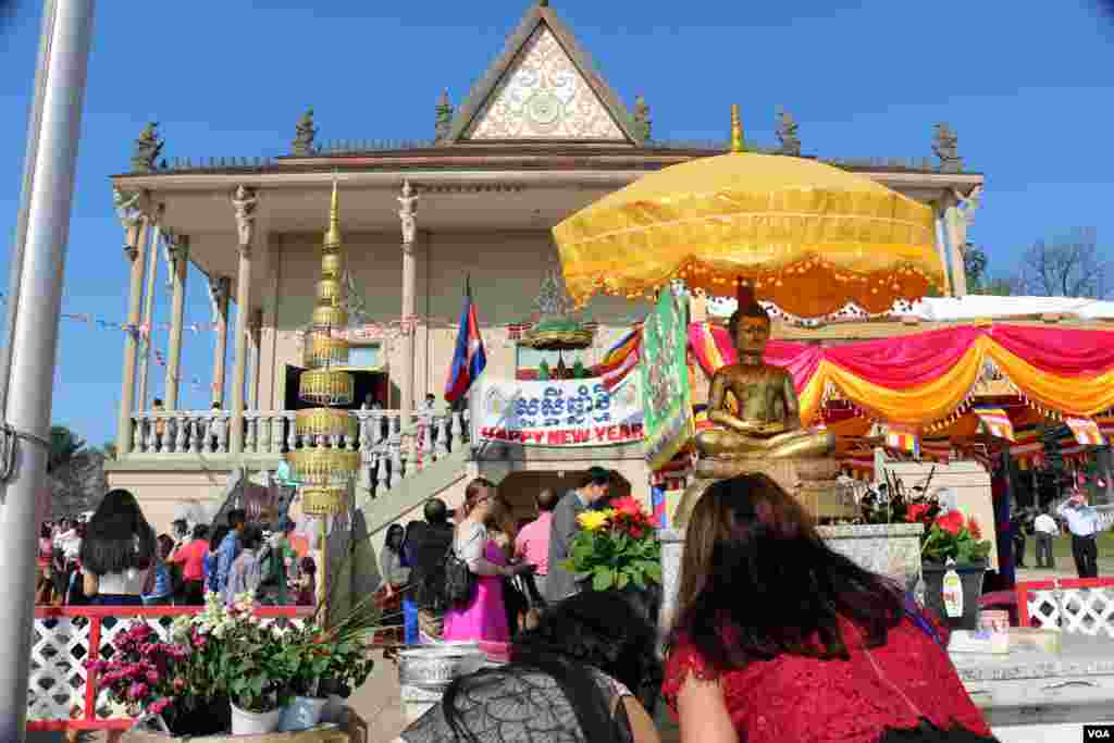 ពុទ្ធបរិស័ទពីររូបអុចធូបថ្វាយព្រះពុទ្ធ។ (ចាប ចិត្រា/VOA)