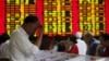 Investors look at computer screens showing stock information at a brokerage house in Shanghai, China, July 8, 2015.