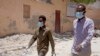 Somali men wear surgical masks on the street after after the government announced the closure of schools and universities and banned large gatherings, Mogadishu, March 18, 2020.