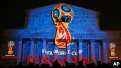 Journalists look at a light installation showing the official logotype of the 2018 FIFA World Cup during its unveiling ceremony at the Bolshoi Theater building in Moscow, October 28, 2014. REUTERS/Maxim Shemetov (RUSSIA - Tags: SPORT SOCCER WORLD CUP MEDI