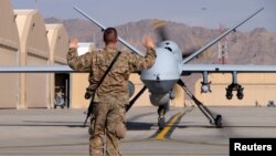 A U.S. airman guides a U.S. Air Force MQ-9 Reaper drone as it taxis to the runway at Kandahar Airfield, Afghanistan March 9, 2016.