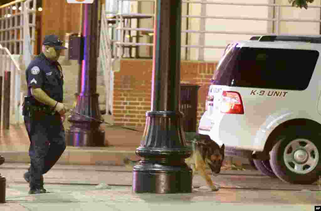 Des agents de l’ordre recherchent des explosifs après une fusillade au centre-ville de Dallas, 8 juillet 2016. (AP Photo / LM Otero)