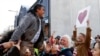 FILE - Mosque shooting survivor Abdul Aziz is held aloft as he thanks supporters outside the Christchurch High Court after the sentencing hearing for Australian Brenton Harrison Tarrant, in Christchurch, New Zealand on Aug. 27, 2020. Aziz is one of two wo