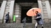 A woman walks past in front of Bank of Japan, Jan. 29, 2016. The Bank of Japan on Friday introduced a negative interest policy for the first time, seeking to shore up a stumbling recovery in the world's third-largest economy. 