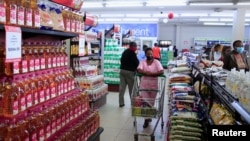 Des clients font leurs courses dans une épicerie à Harare, au Zimbabwe, le 17 mars 2022.