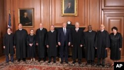 In this image provided by the Supreme Court, President Donald Trump poses with members of the Supreme Court, June 15, 2017, at the court in Washington. 