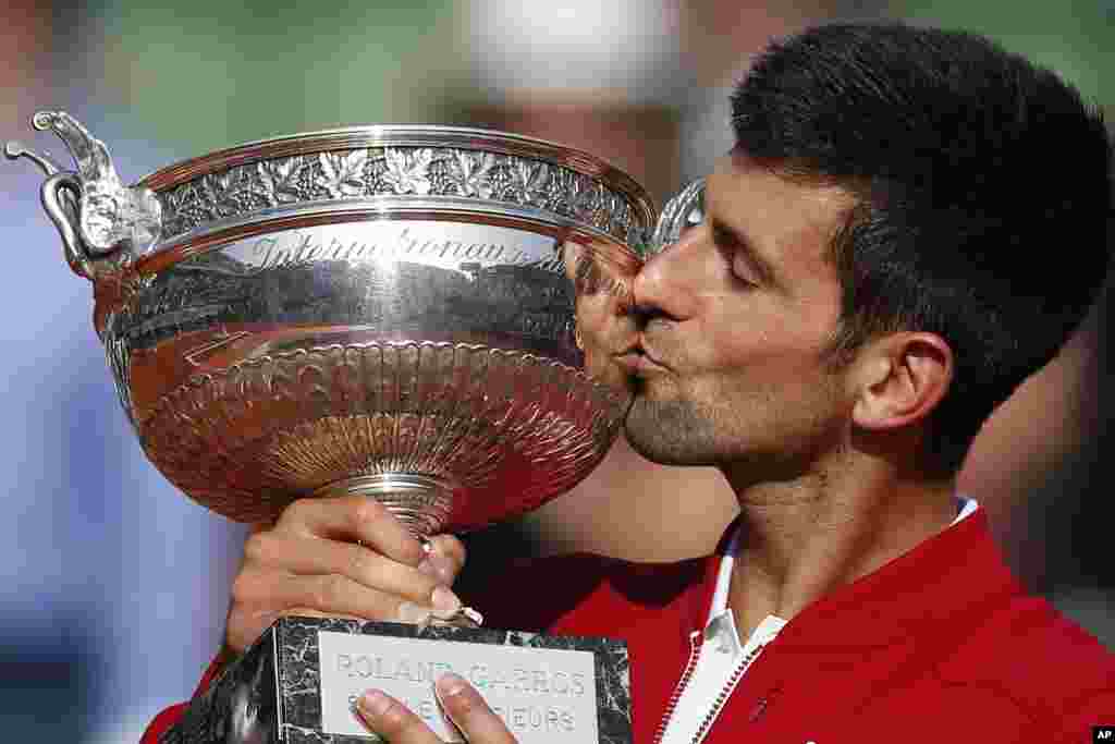 Serbia's Novak Djokovic kisses the trophy after winning the final of the French Open tennis tournament against Britain's Andy Murray in four sets 3-6, 6-1, 6-2, 6-4, at the Roland Garros stadium in Paris, France.