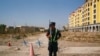 FILE - A Chinese police officer takes his position by the road near what is officially called a vocational education center in Yining in Xinjiang Uighur Autonomous Region, China, Sept. 4, 2018. 
