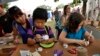 FILE - Attendees create DIY puzzle feeders to enrich the feeding experience of their cats in the Purina ONE tent at Maker Faire New York.
