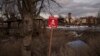 FILE - A sign that reads "Mines" is placed on the side of the road in the village of Kamyanka, Ukraine, on Feb. 19, 2023. In this war-scarred city in Ukraine's northeast, residents scrutinize every step for land mines. 