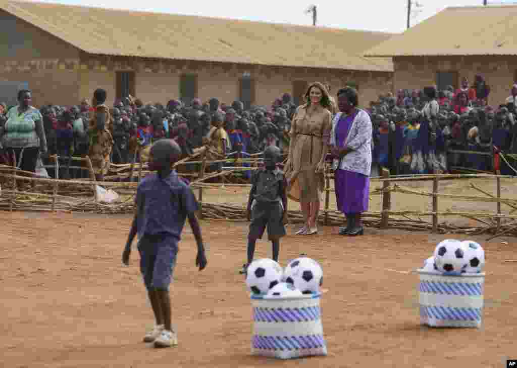 First lady Melania Trump and head teacher Maureen Masi watch children play with soccer balls at Chipala Primary School, in Lilongwe, Malawi, Oct. 4, 2018.