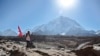 A Nepalese runs with his national flag during a marathon to mark the first conquest of Mount Everest, at Lobuche, near Everest base camp, Nepal, Monday, May 29, 2017. 