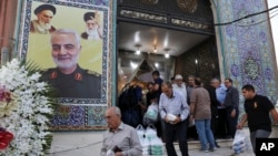 Ljudi napuštaju džamiju u dominantno iračkom južnom kraju Teherana, Iran, 30. jula 2019. Na zidu se vidi poster sa likom generala Qassema Soleimanija, zajedno sa vrhovnim liderom Ali Hameneijem i ajatolahom Homeinijem.