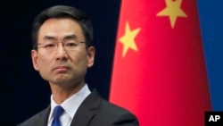 Chinese Foreign Ministry spokesman Geng Shuang listens a question from a reporter during a daily briefing at the Ministry of Foreign Affairs office in Beijing, Wednesday, March 18, 2020. 