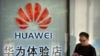 FILE - A man uses his smartphone outside of a shop selling Huawei products at a shopping mall in Beijing, May 29, 2019. 