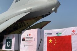 The first batch of COVID-19 vaccine boxes are unloaded from a Pakistan air force plane after arriving from China at the Nur Khan military airbase in Islamabad, Feb. 1, 2021, in this handout picture taken by the Pakistan Health Ministry.