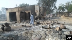 Un homme devant devant des maisons incendiées suite à une attaque par Boko Haram dans Dalori village situé à 5 kilomètres (3 miles) de Maiduguri, au Nigeria, le 31 janvier 2016.