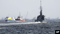 The Republic of Singapore Navy's RSS Brave, right, sails off from the Tuas naval base on a search-and-rescue mission for the USS John S. McCain's missing sailors, Aug. 24, 2017, in Singapore.