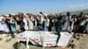 FILE - Relatives and residents pray near a coffin during a funeral ceremony of one of the victims after a drone strike, in Khogyani district of Nangarhar province, Afghanistan Sept. 19, 2019.