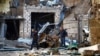 Men walk through the ruins after recent shelling during the military conflict over the breakaway region of Nagorno-Karabakh, Oct. 13, 2020. 