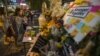 A woman places a flower at the Erawan shrine, the site of Monday's deadly blast, in central Bangkok, Thailand, Aug. 20, 2015.