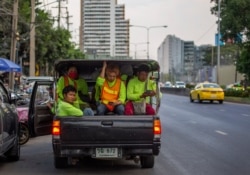 FILE - Migrant construction workers, some wearing face masks to protect against the coronavirus, are seen in a truck after a day's work in Bangkok, Thailand, April 9, 2020.