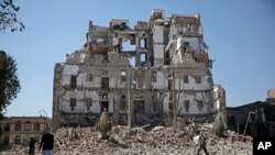 Houthi Shiite rebels walk amid the rubble of the Republican Palace that was destroyed by Saudi-led airstrikes, in Sanaa, Yemen, Dec. 6, 2017.