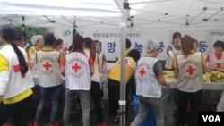 27일 중복을 맞아 하나원 교육생들과 적십자사 회원들이 쪽방촌 주민들에게 삼계탕을 나눠주는 봉사활동을 했다. 참가자들이 삼계탕과 함께 먹을 김치를 만들고 있다.