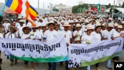 រូប​ឯកសារ៖ ប្រជាជន​កម្ពុជា​កាន់​បដា​ក្នុង​ការ​ដើរ​ក្បូន​ទាមទារ​ក្នុង​ទិវា World Habitat Day។ (AP Photo)