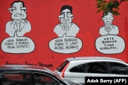 Sebuah mural bertuliskan "Saya Bangga Punya Tiga Rumah Mewah (Kiri), Saya Bangga Punya Lima Mobil Mewah (C), Saya Bangga Tidak Melakukan Korupsi", di dinding sebuah jalan di Jakarta pada tanggal 18 November 2009 .(Foto: AFP/Adek Berry/ilustrasi)