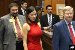 Arizona state Rep. Michelle Ugenti-Rita, center, leaves the House speaker's office along with Reps. Jay Lawrence, left, and Vince Leach, right, in Phoenix, Arizona, Feb. 1, 2018.