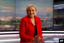 FILE - Former French presidential election candidate for the far-right Front National party Marine Le Pen poses prior to an interview on the evening news broadcast of French TV channel TF1, May 18, 2017, in Boulogne-Billancourt, near Paris.