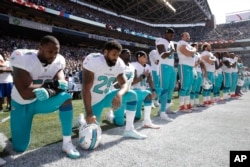 Jelani Jenkins, Arian Foster, Michael Thomas and Kenny Stills kneel during the national anthem, Sept. 11, 2016.
