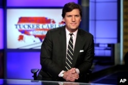 FILE - Tucker Carlson, host of "Tucker Carlson Tonight," poses for photos in a Fox News Channel studio in New York, March 2, 2017.