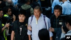 香港壹传媒集团创办人黎智英2014年12月11日在香港政府总部外的“占领区”被警察带走。(资料照)