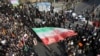 In this photo provided by Tasnim News Agency, a demonstrator waves a huge Iranian flag during a pro-government rally in the northeastern city of Mashhad, Iran, Jan. 4, 2018.