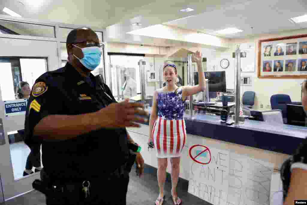 A parent and a member of the &#39;Community Patriots&#39; confronts a police officer while protesting against wearing masks in schools at the Pinellas County Schools Administration Building in Largo, Florida, Aug. 9, 2021.
